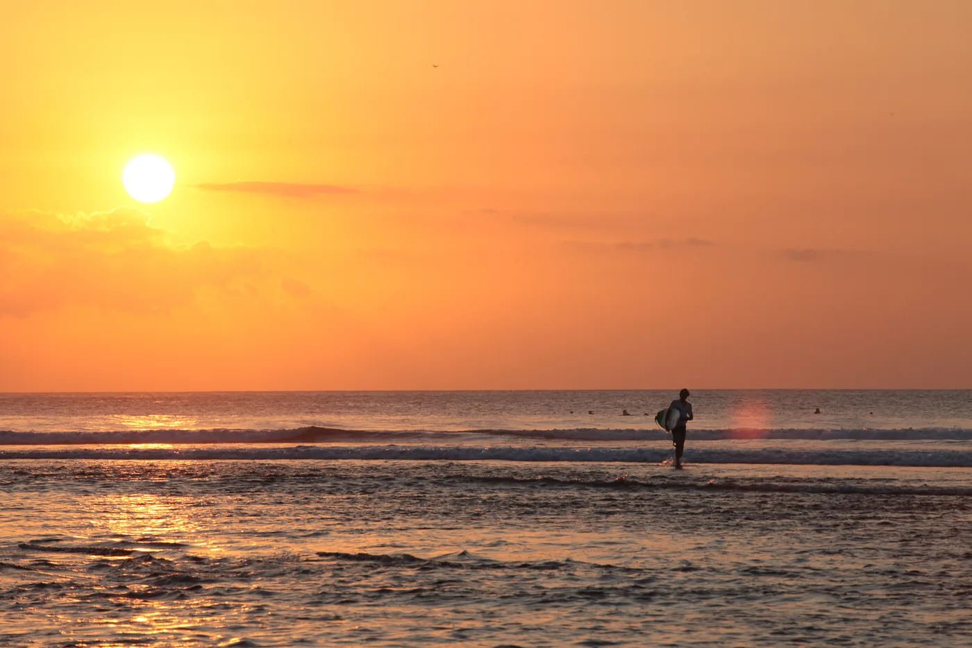 A silhouetted surfer at sunset on Balangan Beach — Surfing at Balangan · illustrative photo, not a lesson location